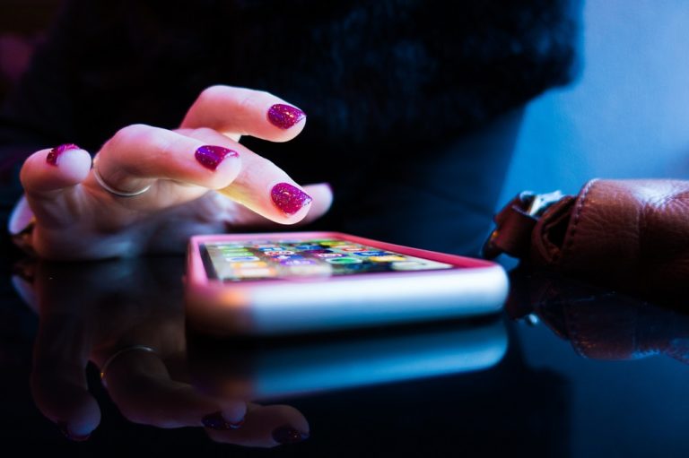 girl selecting app on cell phone